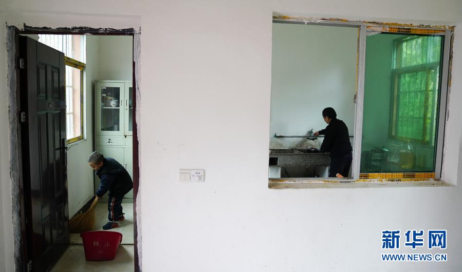 午饭前，江国南（右）在清洗厨具，江昊天帮助老师打扫厨房（12月3日摄）。新华社记者 胡晨欢 摄