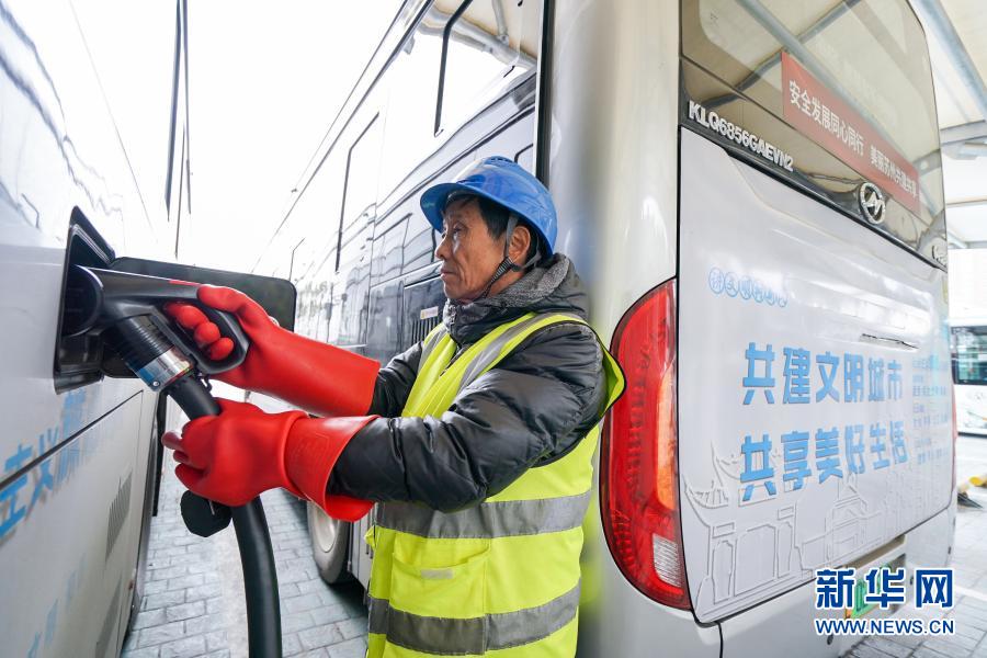 12月7日，在苏州市莲花停保场充电站，工作人员在为电动公交车充电。新华社记者 李博 摄