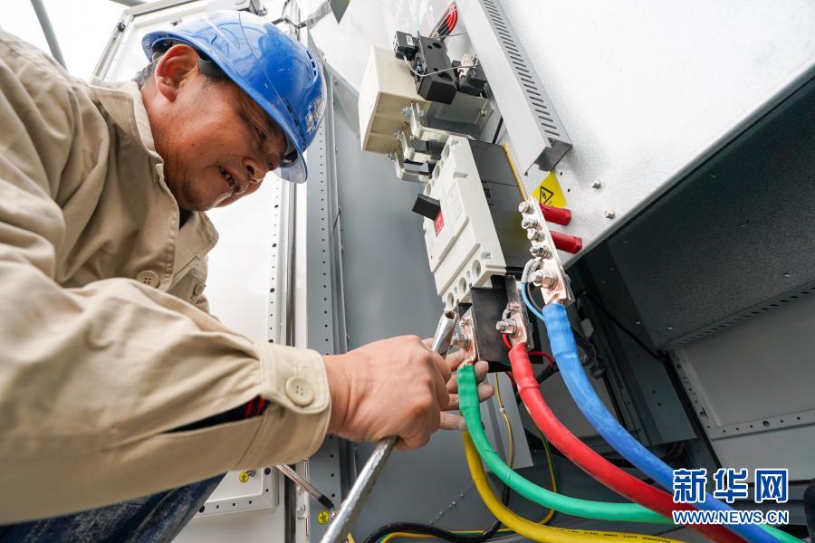 12月7日，在苏州市莲花停保场充电站，国网苏州供电公司的工作人员在安装一体式直流充电桩。新华社记者 李博 摄