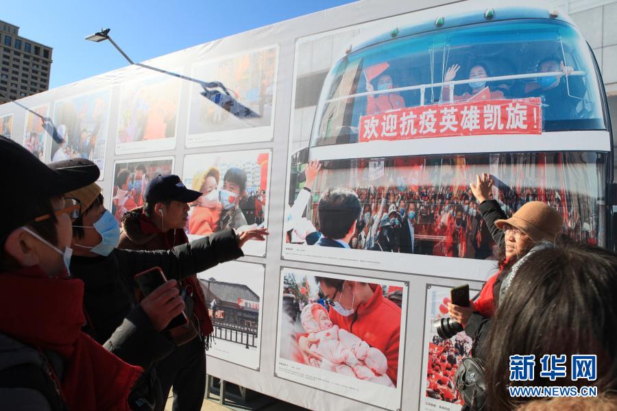 12月7日，观众在抗疫题材照片旁讨论。当日，由中国女摄影家协会、中国妇女儿童博物馆主办的“踏上新征程 砥砺谱新篇——中国女摄影家协会作品展”在北京中华世纪坛开幕，展期持续至12月13日。女性摄影作品集中展示，也成为本届北京国际摄影周的一大亮点。新华社记者 郑悦 摄