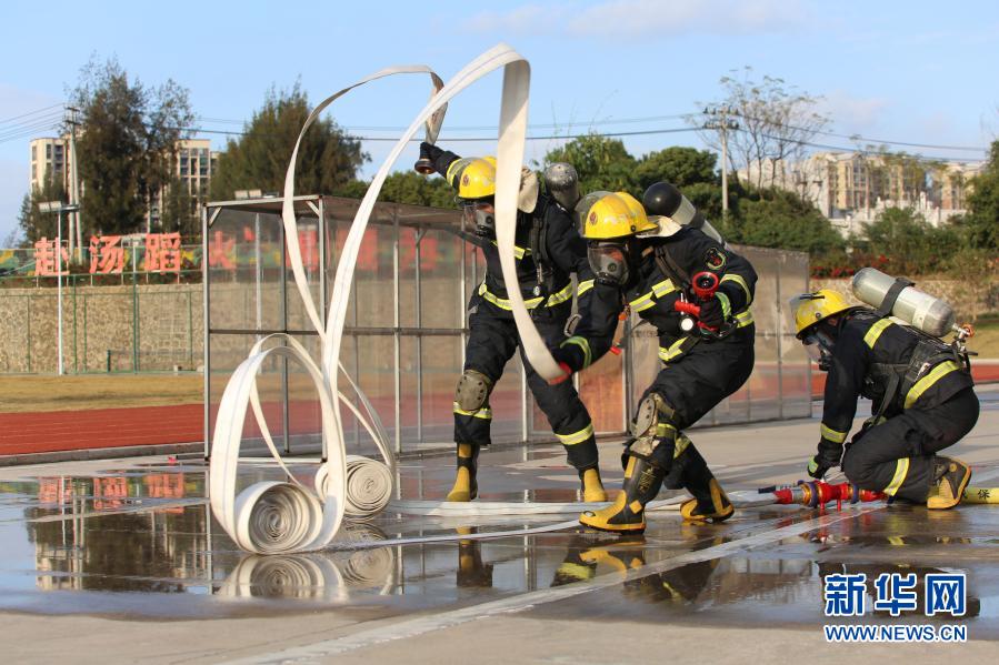 12月9日，在福建省龙岩市消防训练基地，消防员在训练中快速甩开水带。新华社发（周杨东 摄）