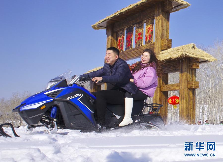 游客在吉林省抚松县东岗镇沿江村体验雪地摩托（2019年2月22日摄）。新华社发