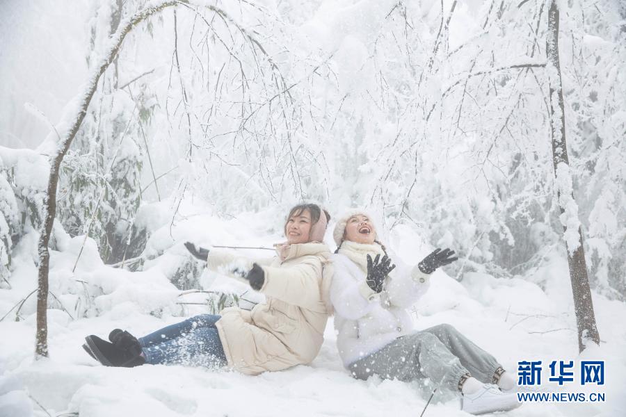 12月12日，两位游客在峨眉山冰雪中嬉戏。12月12日，第22届峨眉山冰雪温泉节开幕，将持续到明年2月。据悉，今年气温低、雪期早、雪量大，雾凇、树挂等冰雪奇观悉数登场，雷洞坪滑雪场也开始接待游人。新华社记者 江宏景 摄