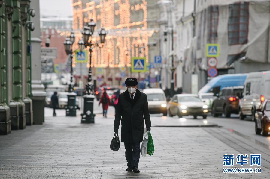 12月16日，在俄罗斯首都莫斯科，一名男子戴口罩出行。新华社发（叶甫盖尼·西尼岑摄）