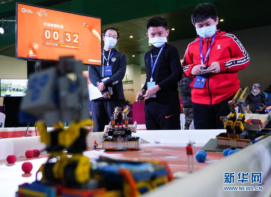 12月20日，在北京中国科学技术馆内举办的2020 Robo Genius人工智能与机器人挑战赛总决赛上，参赛选手卢星皓（右二）、江宸宇（右一）操控机器人完成比赛任务，最终他们获得小学组冠军。当日，2020 Robo Genius人工智能与机器人挑战赛总决赛在北京中国科学技术馆举行。在以“火星探索”为主题的比赛场上，来自全国各地的百余支中小学生队伍比拼机器人完成跨区域行动、碎片收集、阀门开启等任务。经过层层淘汰晋级，最终来自河南的卢星皓、江宸宇获得小学组冠军，来自广东的凌深杰、陈天泽获得初中组冠军。新华社记者 陈钟昊 摄