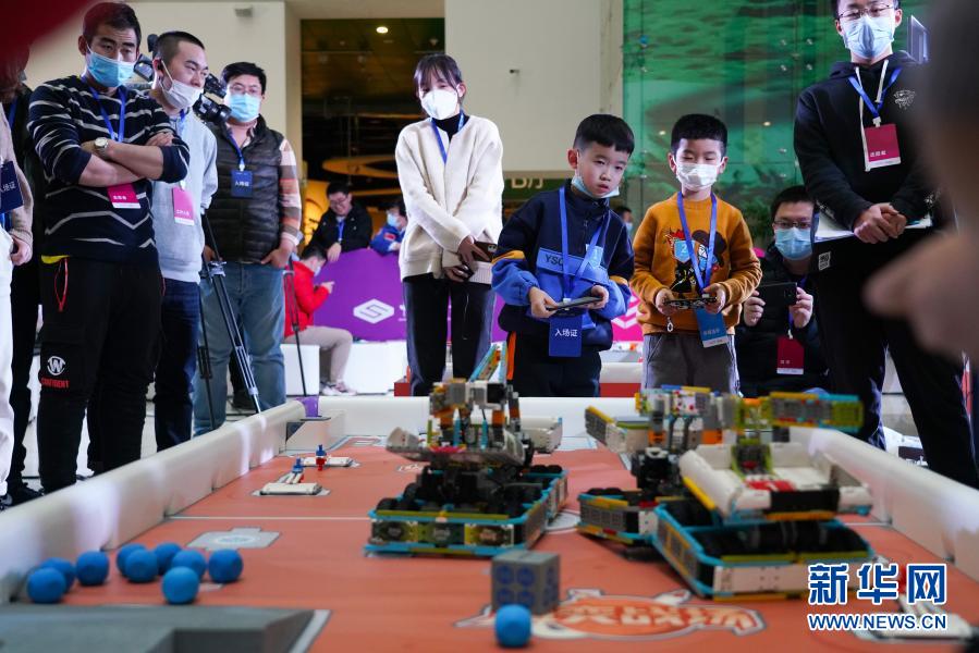 12月20日，在北京中国科学技术馆内举办的2020 Robo Genius人工智能与机器人挑战赛总决赛现场，参赛选手操控机器人完成比赛任务。当日，2020 Robo Genius人工智能与机器人挑战赛总决赛在北京中国科学技术馆举行。在以“火星探索”为主题的比赛场上，来自全国各地的百余支中小学生队伍比拼机器人完成跨区域行动、碎片收集、阀门开启等任务。经过层层淘汰晋级，最终来自河南的卢星皓、江宸宇获得小学组冠军，来自广东的凌深杰、陈天泽获得初中组冠军。新华社记者 陈钟昊 摄