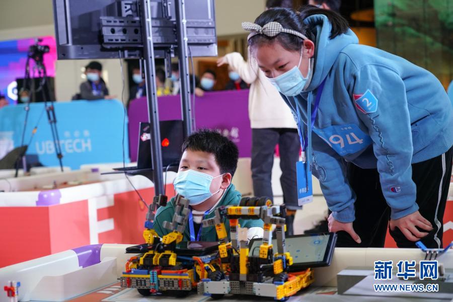12月20日，在北京中国科学技术馆内举办的2020 Robo Genius人工智能与机器人挑战赛总决赛上，参赛选手在赛前检查机器人状态。当日，2020 Robo Genius人工智能与机器人挑战赛总决赛在北京中国科学技术馆举行。在以“火星探索”为主题的比赛场上，来自全国各地的百余支中小学生队伍比拼机器人完成跨区域行动、碎片收集、阀门开启等任务。经过层层淘汰晋级，最终来自河南的卢星皓、江宸宇获得小学组冠军，来自广东的凌深杰、陈天泽获得初中组冠军。新华社记者 陈钟昊 摄