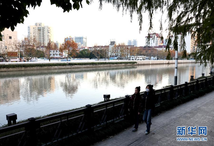 12月20日，游客在苏州河曹杨路桥附近散步休闲。随着上海苏州河沿河景观工程的有序推近，不少岸线已完成贯通和景观美化提升工程。据悉，2020年底，集绿地、道路景观、亲水平台为一身的苏州河中心城区42公里岸线公共空间将基本实现贯通开放。新华社记者 陈飞 摄