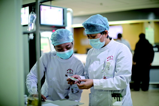 12月17日，贵州医科大学附属医院护士叶青（左）在骨科病房工作。新华社记者刘续摄
