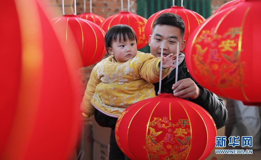 12月21日，在河南省武陟县西陶镇石荆村一家灯笼加工厂，顾客在挑选大红灯笼。新华社发（冯小敏 摄）