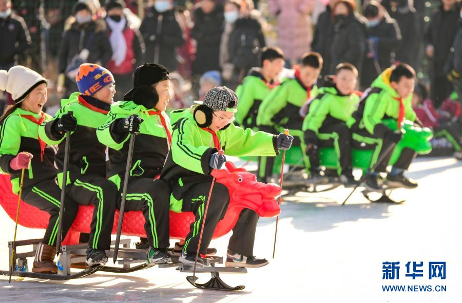 12月21日，乌兰察布市集宁区建国四路小学学生在校园冰雪文化节上参加冰上龙舟比赛。当日，内蒙古自治区乌兰察布市集宁区建国四路小学举办校园冰雪文化节，学生们通过冰上呼啦圈、冰上抽陀螺、滑冰车、冰上龙舟等系列趣味赛事，感受冰雪运动的魅力。新华社发（王正 摄）