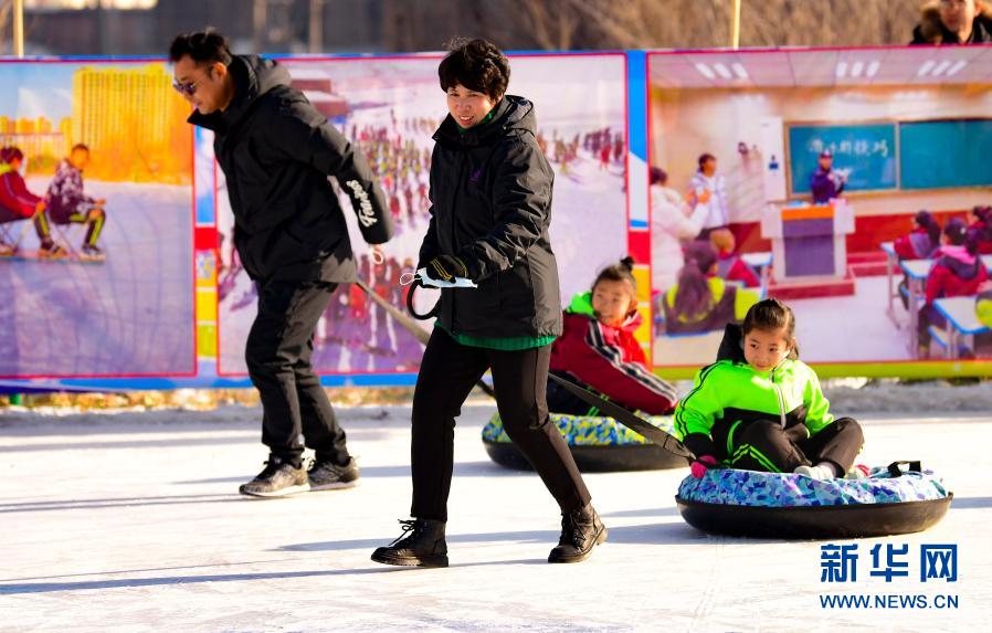 12月21日，乌兰察布市集宁区建国四路小学学生和家长在校园冰雪文化节上参加冰上亲子运动。新华社发（王正 摄）
