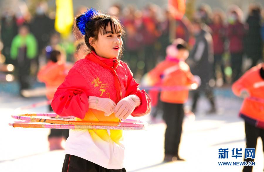 12月21日，乌兰察布市集宁区建国四路小学学生在校园冰雪文化节上表演冰上呼啦圈。新华社发（王正 摄）