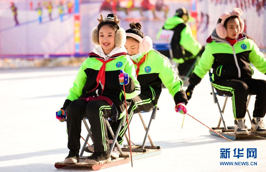 12月21日，乌兰察布市集宁区建国四路小学学生在校园冰雪文化节上参加滑冰车运动。新华社发（王正 摄）