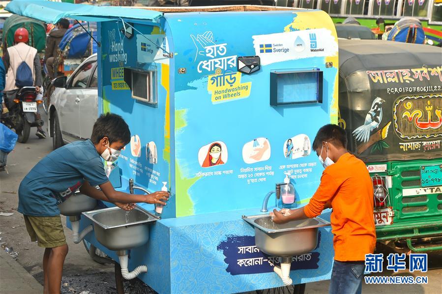 12月21日，在孟加拉国达卡，两名儿童在一处移动洗手设施洗手。 孟加拉国卫生部门20日公布的数据显示，该国新冠累计确诊病例超50万例。 新华社发