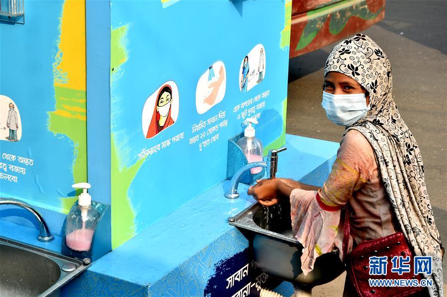 12月21日，在孟加拉国达卡，一名女孩在一处移动洗手设施洗手。 孟加拉国卫生部门20日公布的数据显示，该国新冠累计确诊病例超50万例。 新华社发