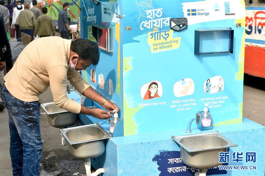12月21日，在孟加拉国达卡，一名男子在一处移动洗手设施洗手。 孟加拉国卫生部门20日公布的数据显示，该国新冠累计确诊病例超50万例。 新华社发