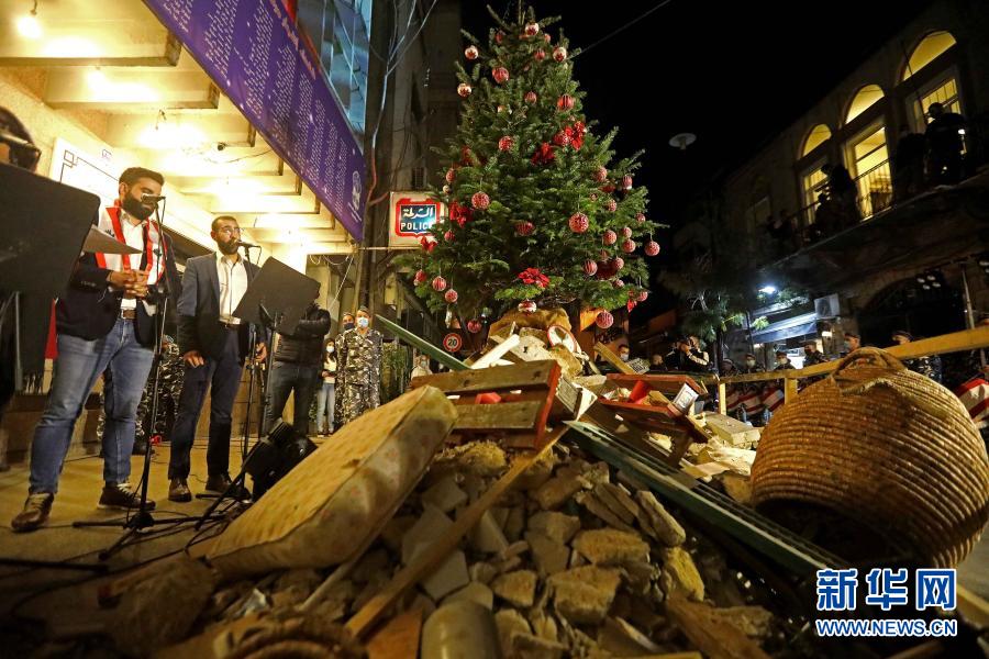 12月22日，在黎巴嫩贝鲁特，警方在一处废墟上举行点亮圣诞树的活动。新华社发（比拉尔·贾维希摄）