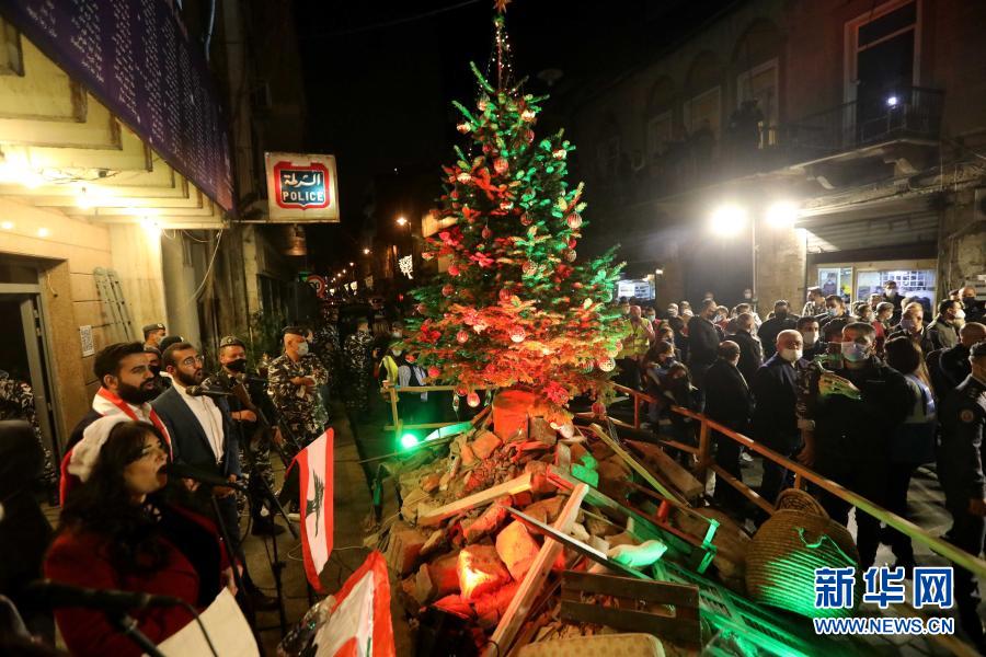 12月22日，在黎巴嫩贝鲁特，警方在一处废墟上举行点亮圣诞树的活动。新华社发（比拉尔·贾维希摄）