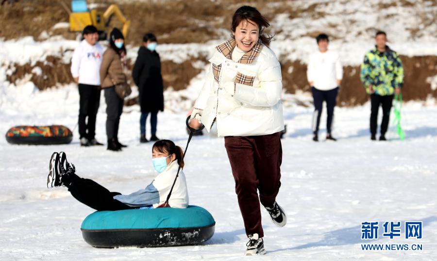 12月23日，一对选手在参加拉雪圈比赛。当日，河北省沧州市沧县举行冰雪趣味运动会，百余名选手参加了拉雪圈、雪地保龄球、雪地跳绳、雪地爬犁等项目的比拼，运动会将趣味竞赛与全民健身结合，让群众享受冰雪运动带来的快乐。新华社发（周洋 摄）