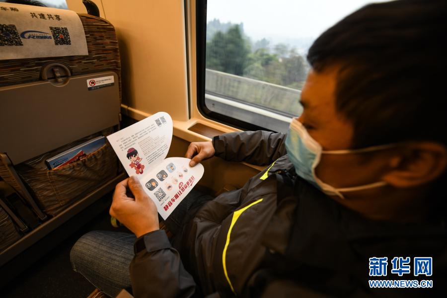 12月24日，在成渝高铁成都东至沙坪坝G8609次列车上，一位乘客翻看“静音车厢”服务提示卡。新华社记者 王曦 摄