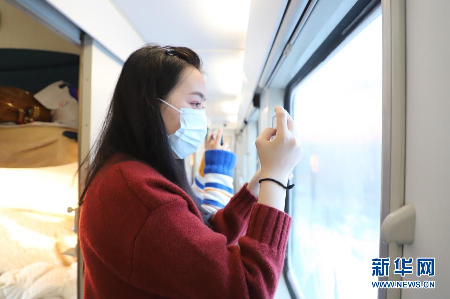 在K7039次列车上，游客拍摄沿途的风景（12月25日摄）。新华社记者 孙晓宇摄