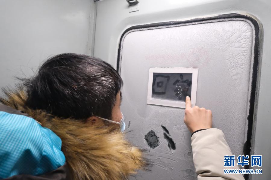 K7039次列车上一名旅客在上霜的车门上写下“回家”（12月24日摄）。新华社记者 黄腾摄