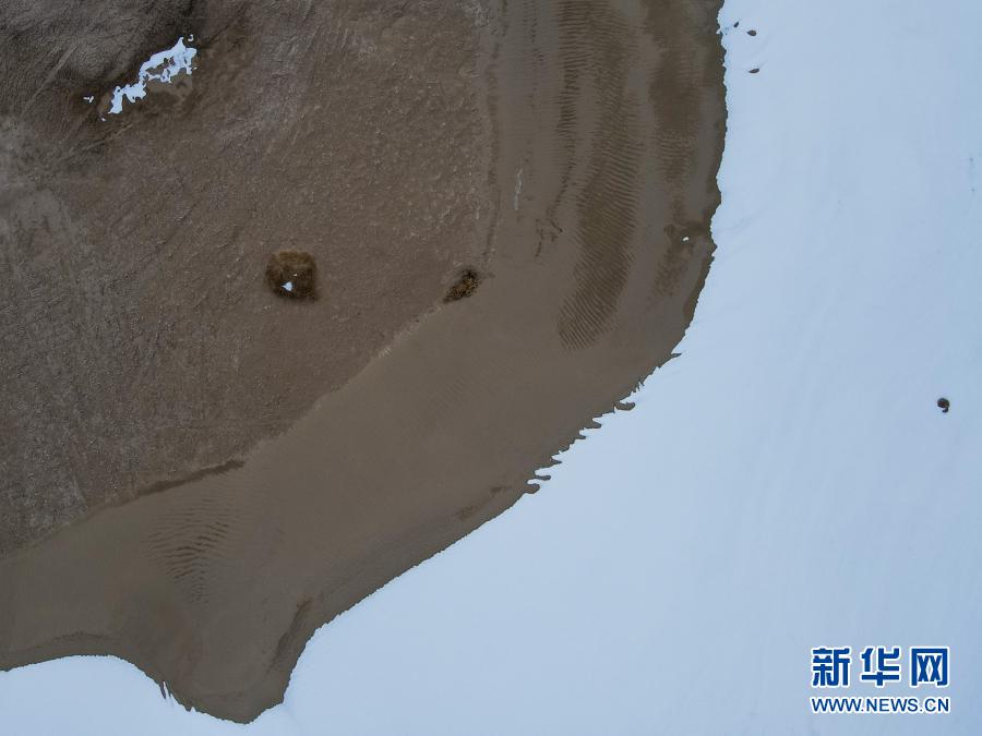 这是白雪映衬下的塔克拉玛干沙漠（无人机照片，12月27日摄）。在新疆岳普湖县达瓦昆沙漠旅游风景区内，塔克拉玛干沙漠在皑皑白雪映衬下更添秀色，黄沙与白雪相映成趣，景色如画。新华社记者 高晗 摄