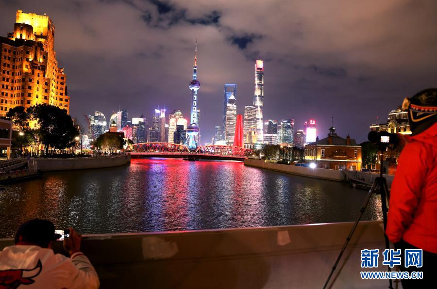 12月28日，游人在苏州河乍浦路桥上拍摄苏州河夜景。新华社记者 陈飞 摄