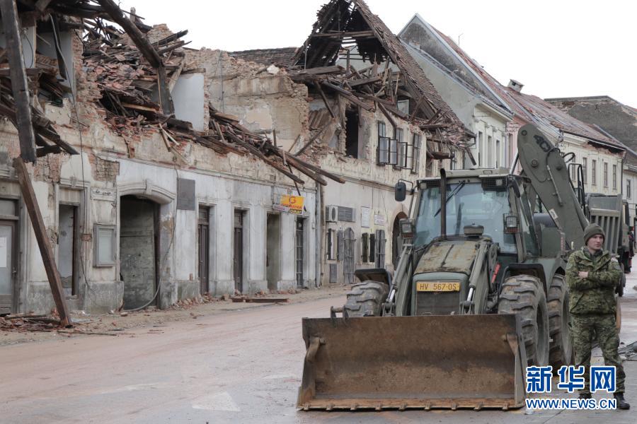 12月30日，一名军人站在克罗地亚彼得里尼亚遭地震损坏的房屋附近。克罗地亚内政部29日晚发布消息说，该国中部当天发生6.4级地震，已造成7人死亡、至少20人受伤。新华社发（雷利亚·杜谢克摄）
