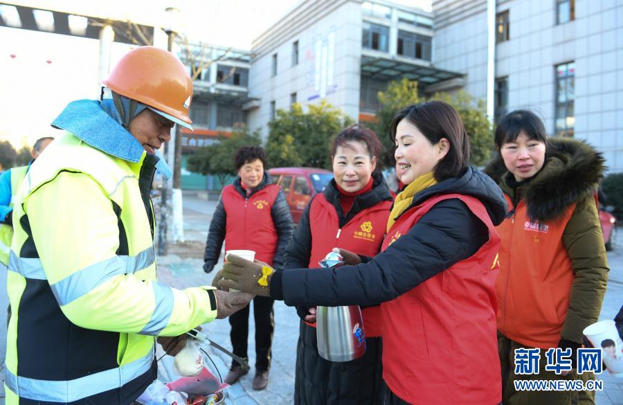 12月31日，“三合大姐巾帼志愿团”志愿者为街头的环卫工人送来早餐。当日清晨，浙江湖州吴兴区八里店镇三合片区开展冬日送温暖活动，志愿者和幼儿园师生为在道路、社区忙碌的环卫工人送来早餐、手套和围巾。新华社记者 翁忻旸 摄