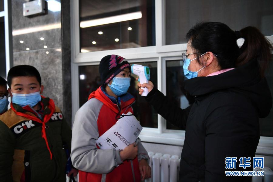 12月31日，学生到达北梁红军小学后接受测温。位于陕西省铜川市耀州区照金镇的北梁红军小学始建于1955年。由于北梁村地处山区，交通不便，这所革命老区里的学校曾经条件艰苦，教学设施落后。近年来，在各级政府和爱心人士的帮助下，学校的办学条件持续改善，由过去的教学点逐步恢复为六年制完全小学。2019年，北梁红军小学扩建的新校舍正式投入使用，宽敞明亮的教室、标准化操场、科普馆、实验室等硬件设施使学校面貌焕然一新。新华社记者 张博文 摄