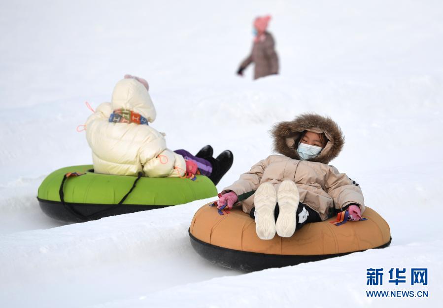 2021年1月1日，小朋友在新疆阿勒泰市桦林公园“桦林冬奥冰雪乐园”雪上项目区玩雪圈。新华社记者 沙达提 摄
