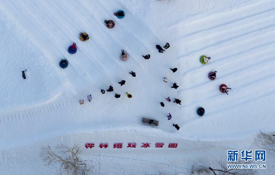 2021年1月1日，人们在新疆阿勒泰市桦林公园“桦林冬奥冰雪乐园”雪上项目区玩雪圈（无人机照片）。新华社记者 沙达提 摄