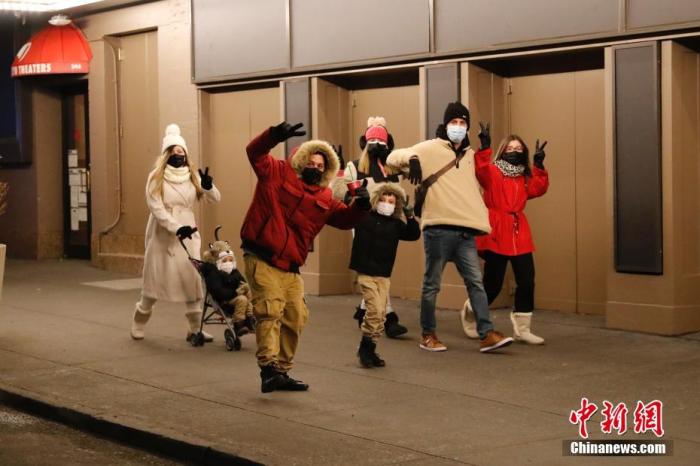 图为31日晚,几名行人走在时报广场附近的街道上。<a target='_blank' href='http://www.chinanews.com/'>中新社</a>记者 马德林 摄 点击进入下一页