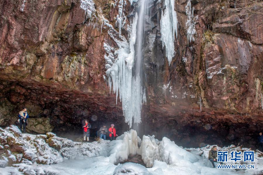 2021年1月3日，游客在余姚市四明山鹁鸪岩欣赏冰瀑。近日，受冷空气的影响，浙江省余姚市四明山鹁鸪岩出现一道高10余米的冰瀑，吸引游人前往观赏。新华社发（张辉 摄）
