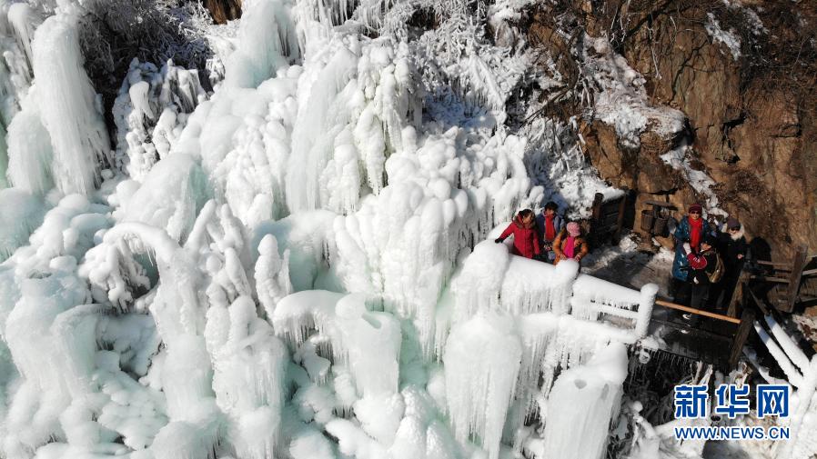 2021年1月5日，游客在济南九如山度假风景区欣赏冰瀑（无人机照片）。近日，济南九如山度假风景区依托原有的八潭九瀑旅游资源，通过引流形成多处造型各异的冰瀑群，吸引不少游客前来欣赏。新华社记者 王凯 摄