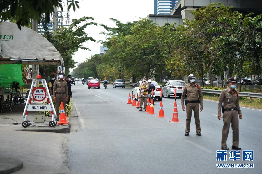 1月5日，警察在泰国曼谷的一处防疫检查站工作。泰国自1月4日起开始对包括曼谷在内的全国28个府级行政区实施为期1个月的严格管制措施，以控制疫情快速蔓延趋势。新华社发（拉亨 摄）