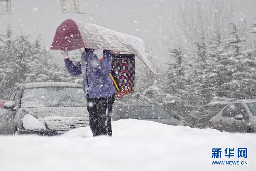 1月5日，在山东烟台街头，行人冒雪出行。 当日是小寒节气，受强冷空气影响，山东烟台迎来降雪。 新华社发（唐克 摄）