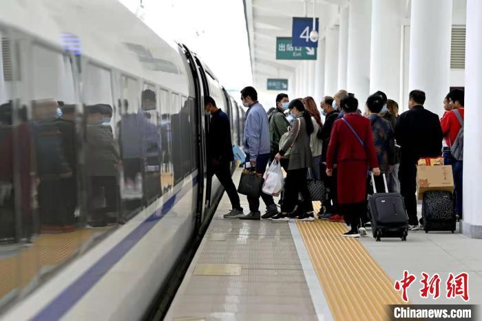 资料图:出行旅客正在有序排队上车中。王甜 摄 点击进入下一页