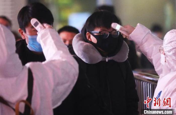 资料图:图为防疫人员正在给旅客测温。 泱波 摄 点击进入下一页