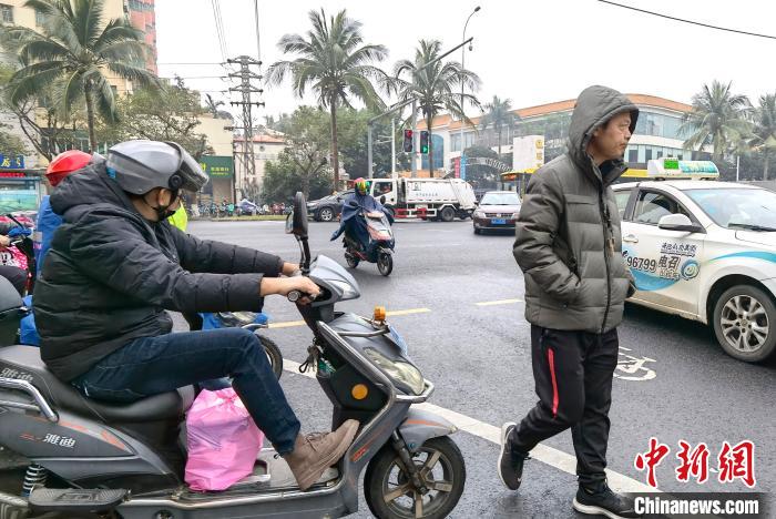 1月7日，海南海口，行人穿上冬装御寒。　尹海明 摄