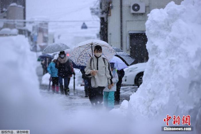 资料图:日本新潟县的学生在雪天行走。 点击进入下一页