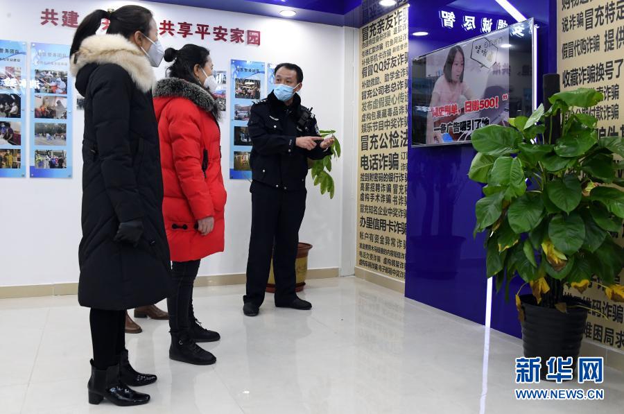 1月10日，在北京市公安局海淀分局永定路派出所第三社区警务工作站展示区，社区民警屈超直（右一）向社区居民介绍防诈骗知识。当日是首个中国人民警察节，在做好疫情防控的前提下，北京市公安局海淀分局永定路派出所第三社区警务工作站举办警务开放日活动。社区居民在警务工作站展示区通过社区民警的介绍了解防盗、防诈骗、禁毒等知识。新华社记者 任超 摄