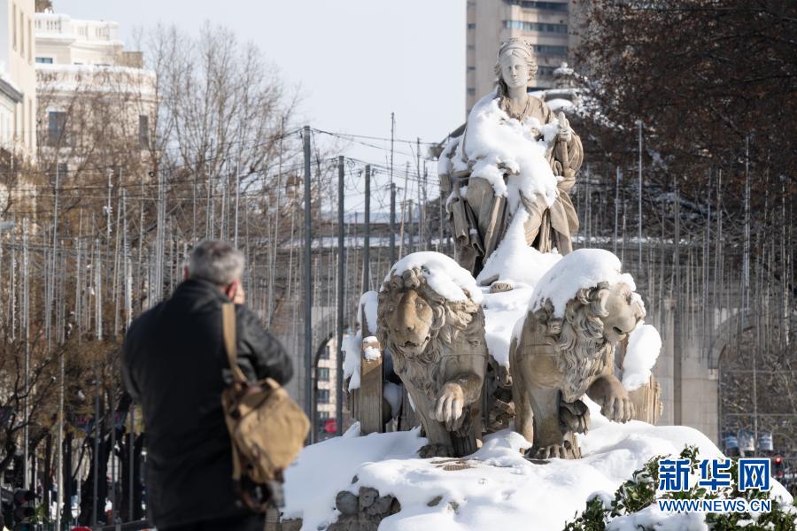 1月10日，一名男子在西班牙马德里市中心拍摄丰收女神雕塑。新华社记者 孟鼎博 摄