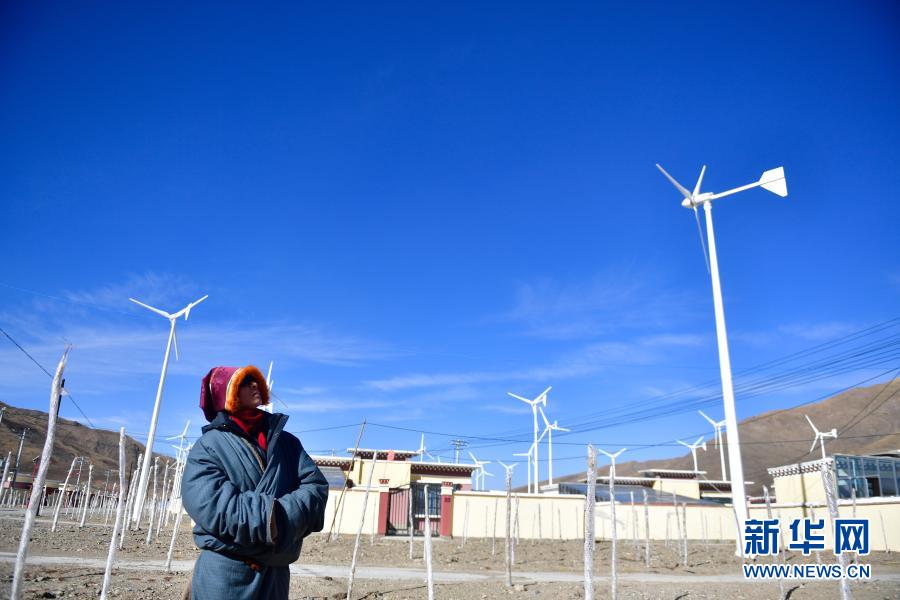 1月11日，隆亚村村支部书记贡保多杰在查看搬迁点的风力发电机组运行情况。新华社记者 张龙 摄