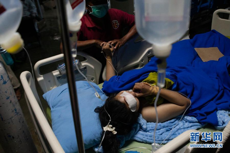 1月15日，在印度尼西亚西苏拉威西省首府马穆朱，一名地震中受伤的女子接受治疗。印尼西苏拉威西省当天凌晨发生的6.2级地震已致42人死亡。新华社发（爱资哈里摄）