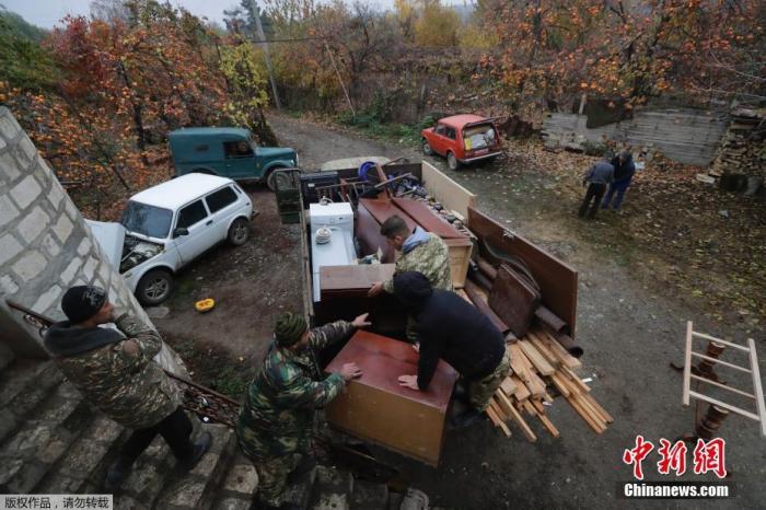 当地时间11月18日,纳卡地区的一个村庄里,准备搬离村庄的民众正在打包行李装车。 点击进入下一页