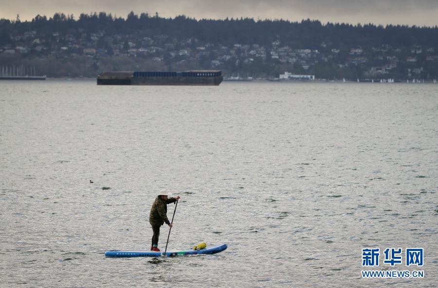 1月17日，在加拿大温哥华，一名男子在海上划立式桨板。截至当地时间16日中午，加拿大累计新冠确诊病例已超过70万例。在疫情下，温哥华仍有不少民众到海滩和公园散步，舒缓应对疫情的生活压力。新华社发（梁森摄）