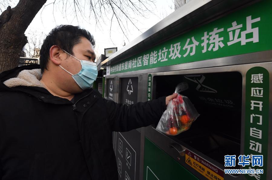 1月18日，在北京市海淀区中关村街道东里南社区智能垃圾分拣站，社区居民投放垃圾。近期，北京市海淀区中关村街道通过引入智能垃圾分拣站、垃圾分类监管平台两个试点助力垃圾分类。据了解，智能垃圾分拣站可通过红外感应、机械手等设备实现厨余垃圾整包投放、免手动破袋等功能。垃圾分类监管平台可实时了解社区居民投放垃圾情况，如遇到社区居民垃圾投放不规范，该平台可通过设置在垃圾驿站的语音提示系统进行提示。新华社记者 任超 摄